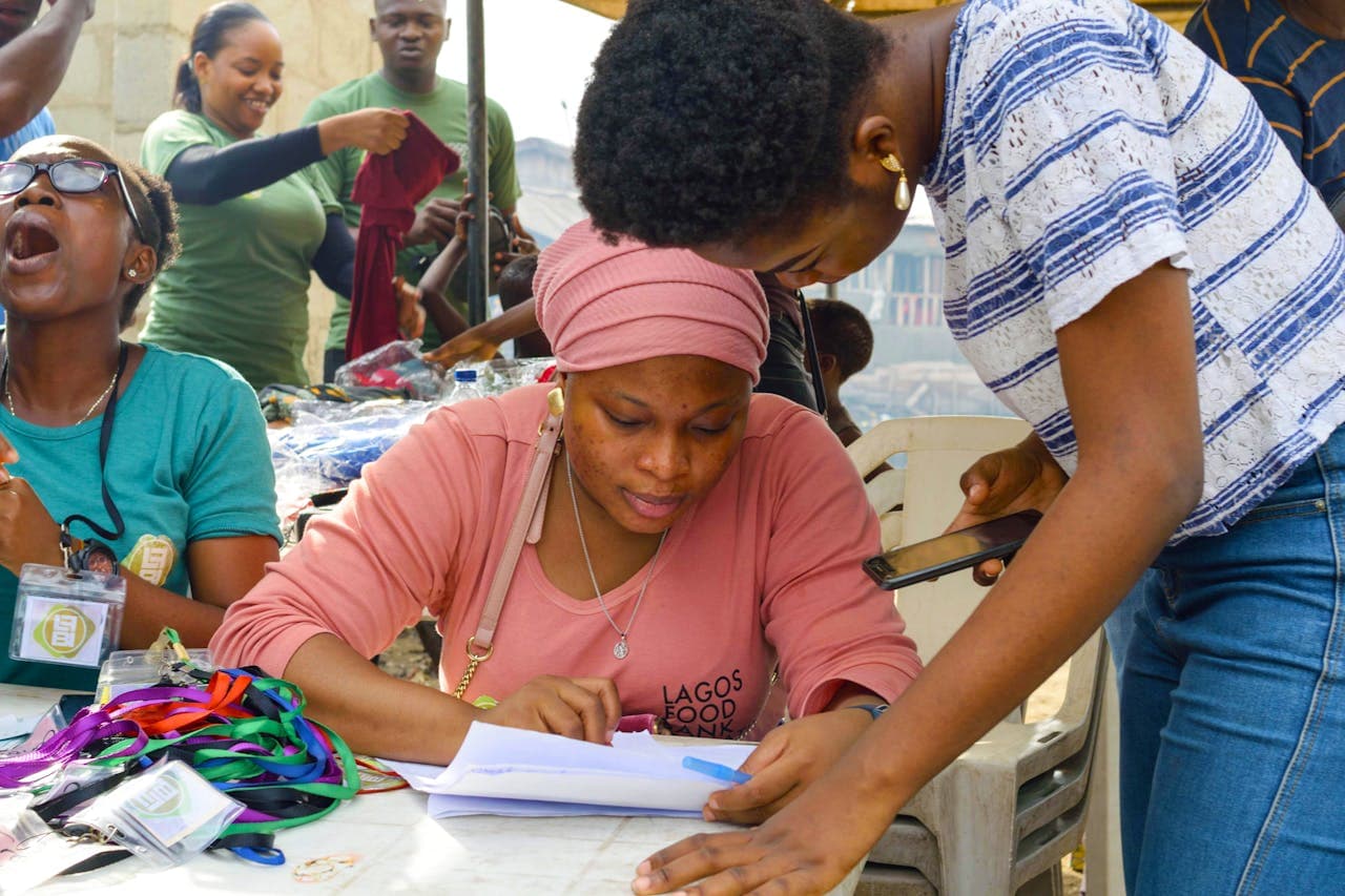 Field coordinator reviewing documents at a community distribution event